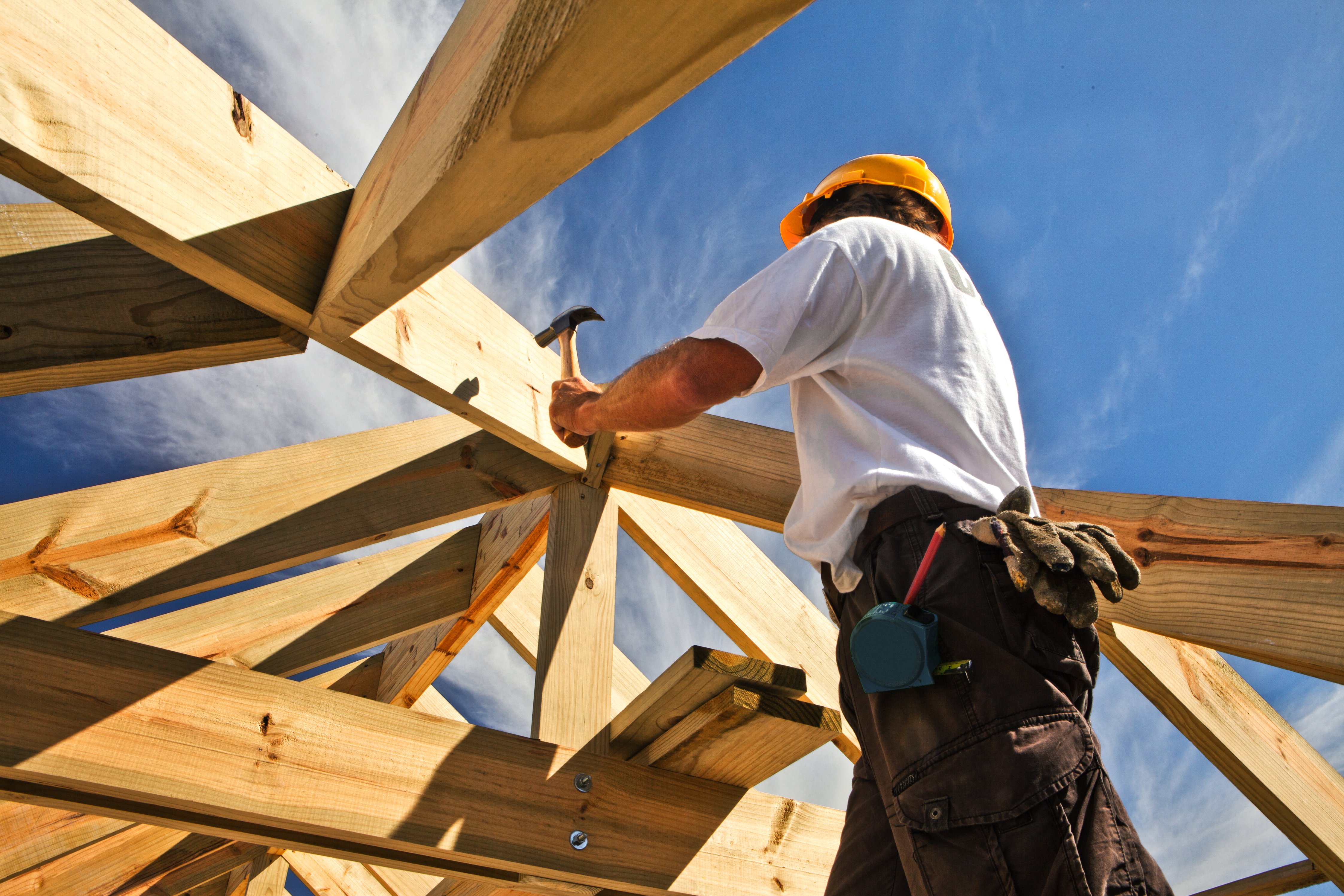 roofer worker builder working on roof structure at construction site